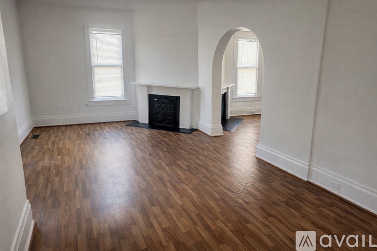 A room with a fireplace and wooden floors.
