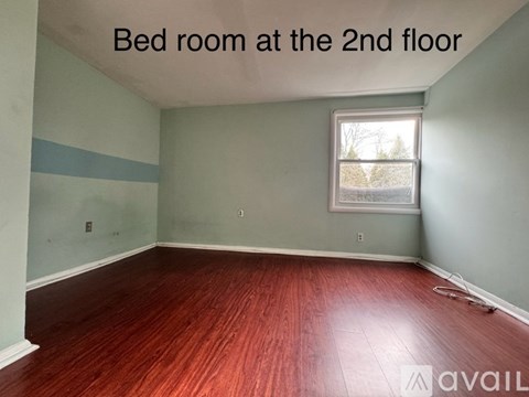 A bedroom with a window on the second floor.