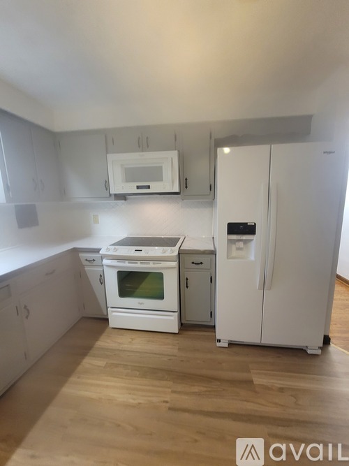 A kitchen with white appliances and cabinets.