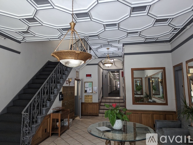 A spacious lobby with a staircase and a glass table.