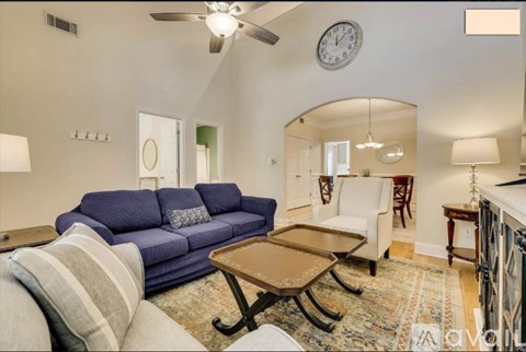 A living room with a blue couch and a wooden coffee table.