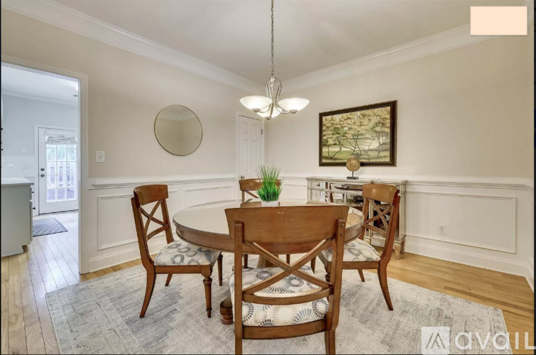 A dining room with a round table and chairs.