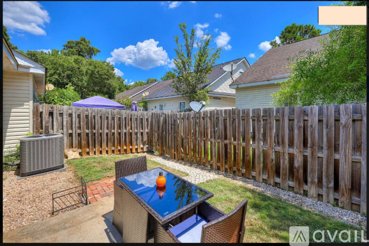 A backyard with a pool table and a fence.