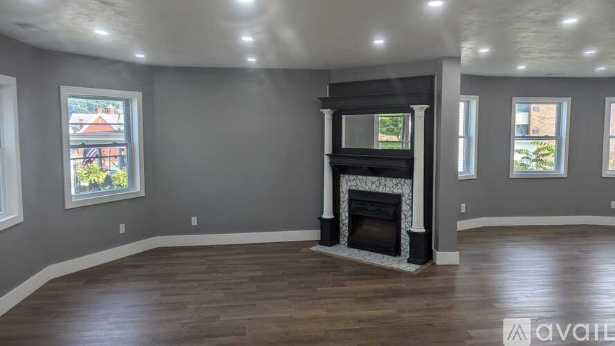 A living room with a fireplace and wood flooring.