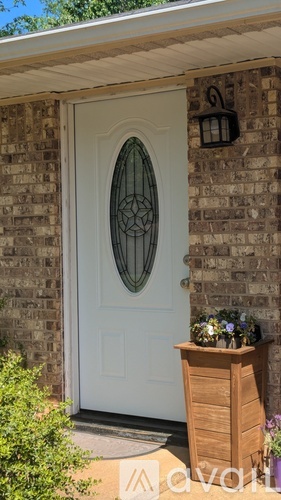 A white door with a glass window and a wooden planter box.