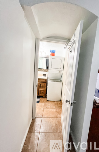 A small kitchen with a refrigerator, sink, and wooden cabinets.
