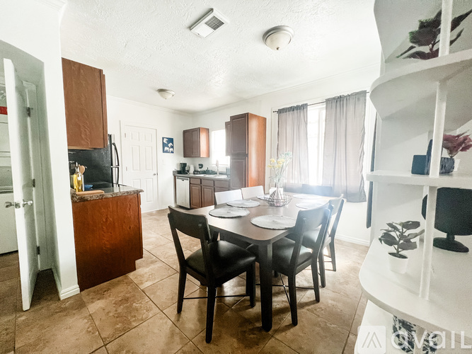 A kitchen with a table and chairs in the middle of the room.