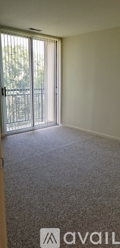 A room with a carpeted floor and a sliding glass door.