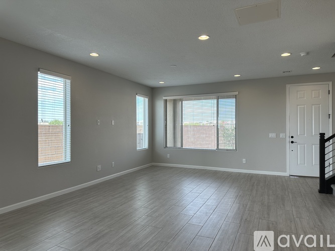 A spacious room with wooden flooring and a white door.