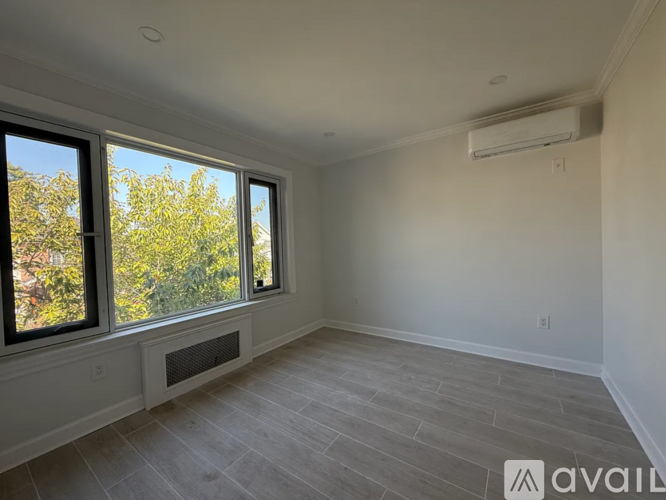 A room with a window and a wall-mounted air conditioner.