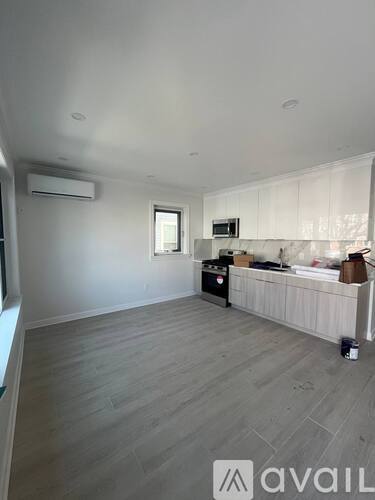 A kitchen area with a white cabinet and a microwave on top of it.