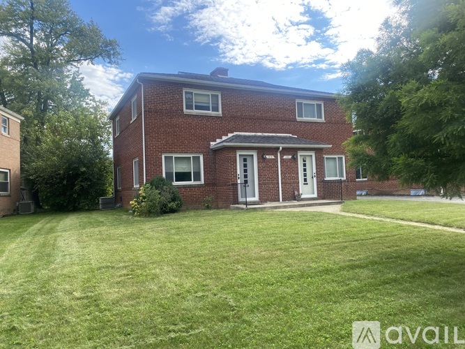 A red brick house with a white door and windows.