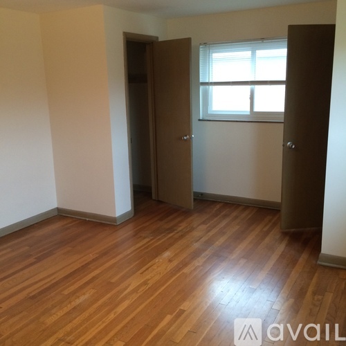 A room with wooden floors and two brown doors.