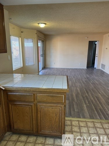 A kitchen with wooden cabinets and a tiled floor.
