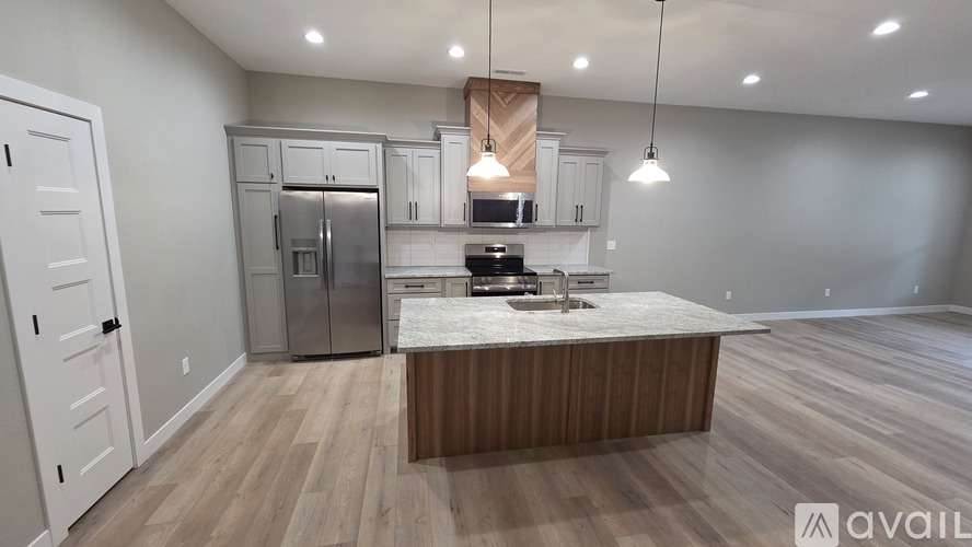 A kitchen with a refrigerator, microwave, and sink.