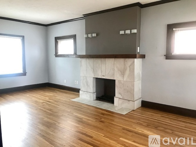 A room with a fireplace and wooden floors.