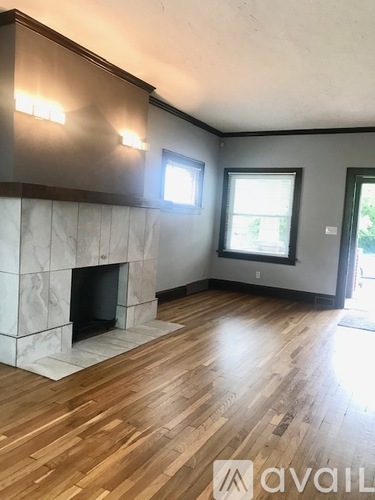 A room with a fireplace and wooden flooring.