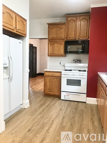 A kitchen with wooden cabinets and a white fridge.