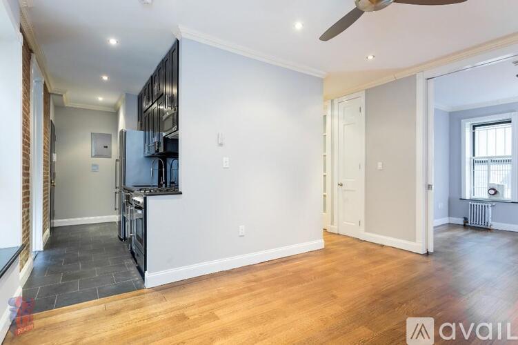 A spacious room with a ceiling fan and wooden flooring.