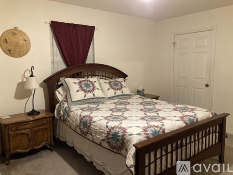 A bedroom with a bed, dresser, and chair.