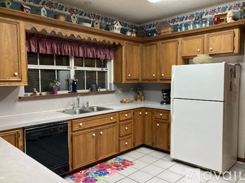 A kitchen with wooden cabinets and a white refrigerator.