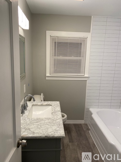 A bathroom with a marble sink and a bathtub.