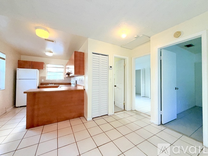 A kitchen with white appliances and a wooden island.