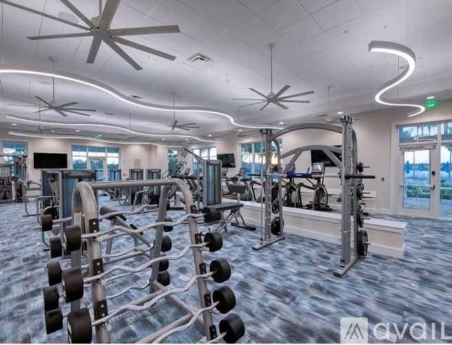 A gym with a variety of equipment including treadmills, weights, and exercise machines.