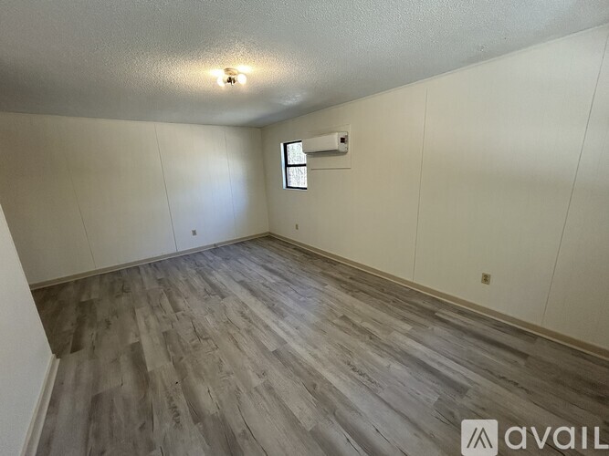 A room with wooden flooring and a window.