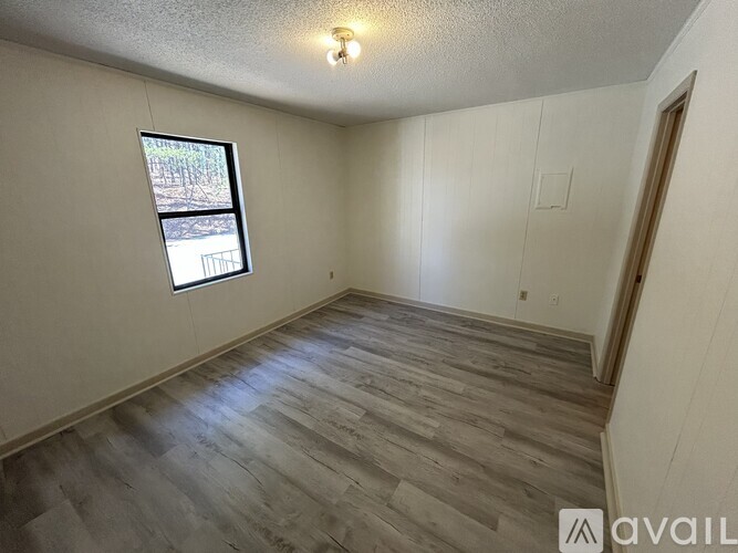 A room with wooden flooring and a window.