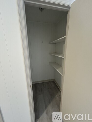 A small, empty pantry with white walls and shelves.