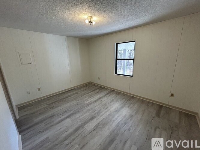 A room with a window and wooden flooring.