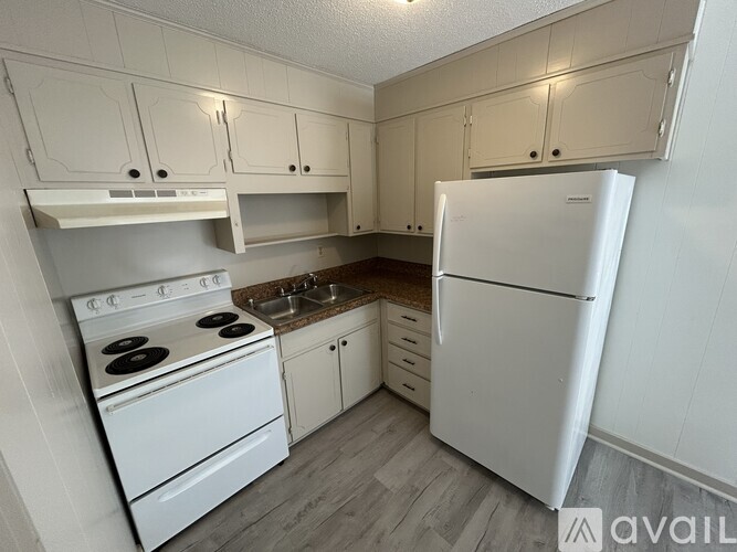 A kitchen with white appliances and cabinets.