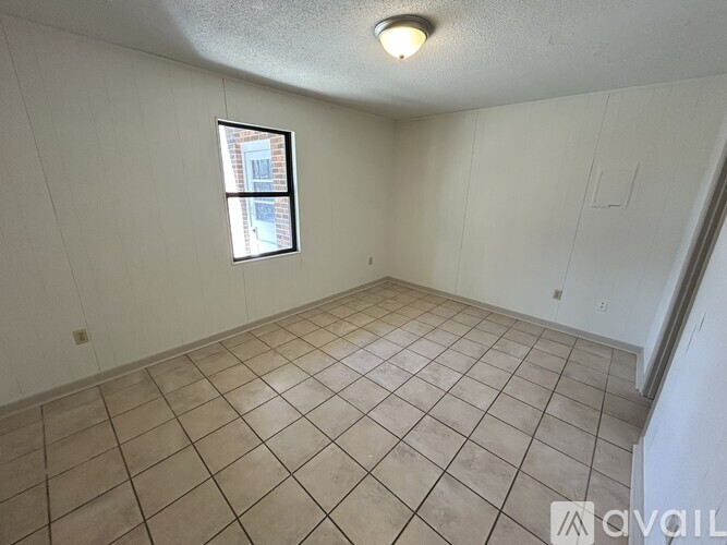 Empty room with tiled floor and a window.