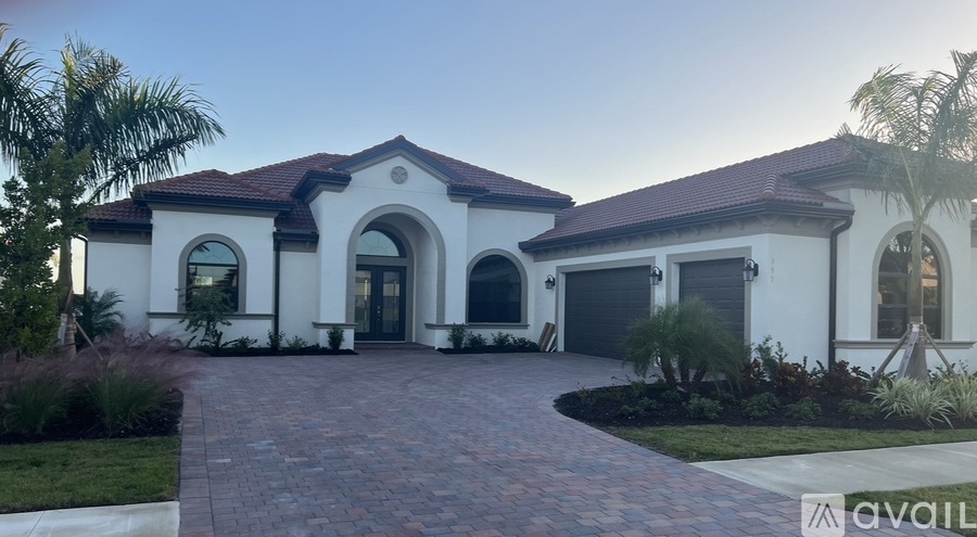 A white house with a brick pathway leading to the front door.
