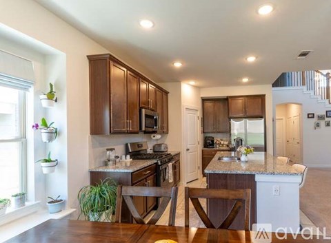 A kitchen with brown cabinets and a dining table with chairs.