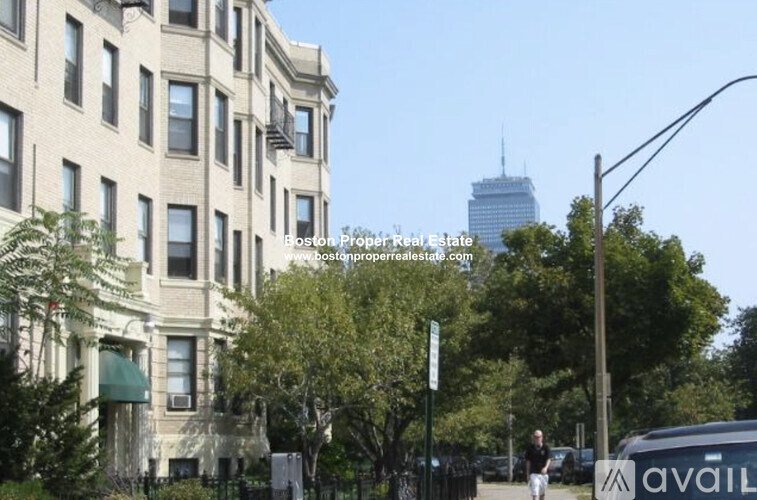 A street view of a building with a sign for Boston Proper Real Estate.
