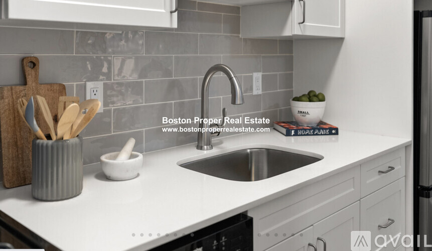 A kitchen with a sink and a website address on the counter.