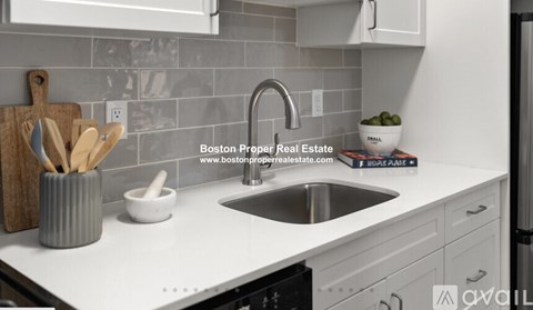 A kitchen with a sink and a website address on the counter.