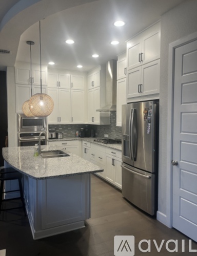 A kitchen with a granite countertop and stainless steel appliances.