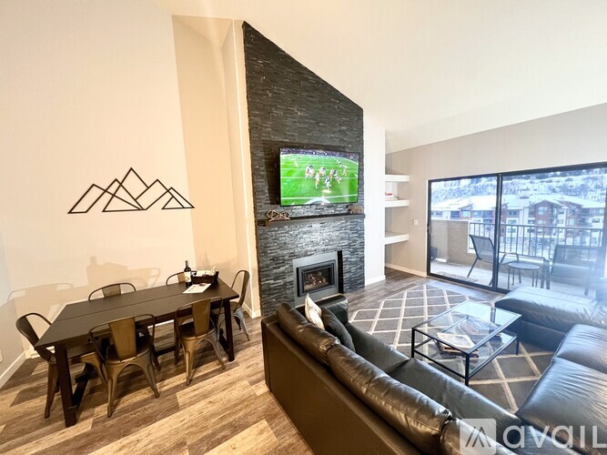 A living room with a fireplace and a TV showing a football game.
