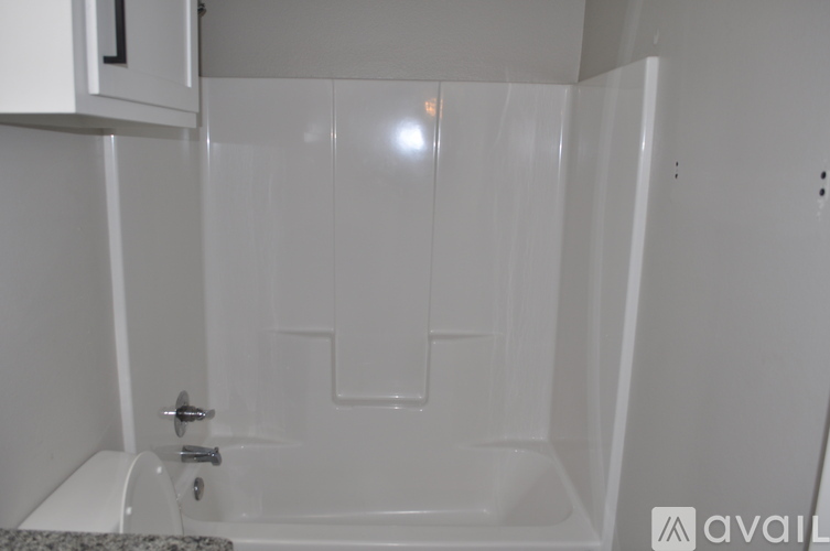 A white bathroom with a tub and toilet.