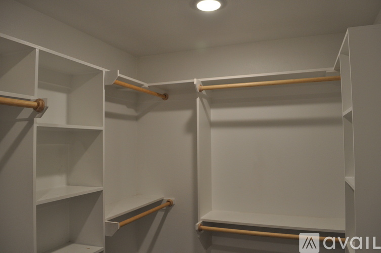 A white closet with shelves and hangers.