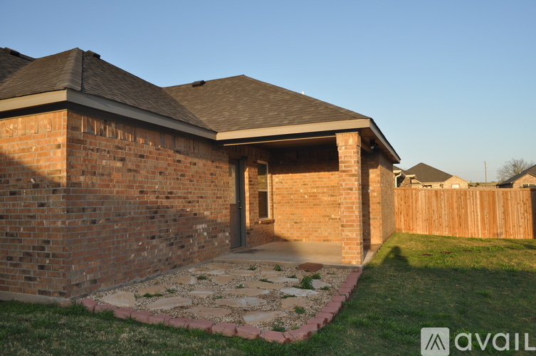 A house with a brick wall and a stone pathway leading to the entrance.