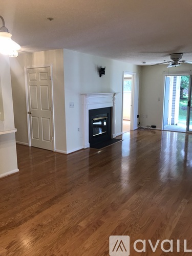 A living room with a fireplace and wood flooring.