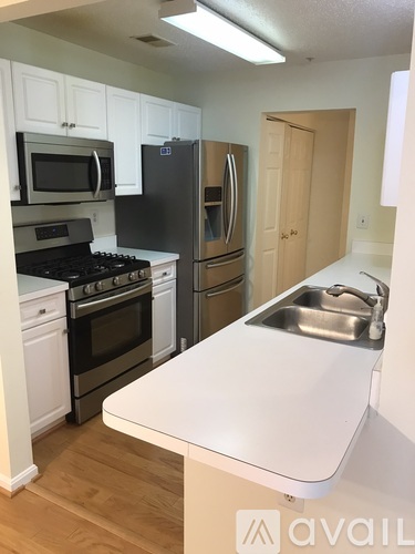 A kitchen with a white counter top and a sink.