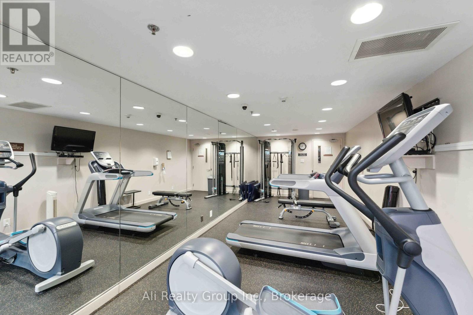 A well-lit gym with treadmills, elliptical machines, and other exercise equipment.