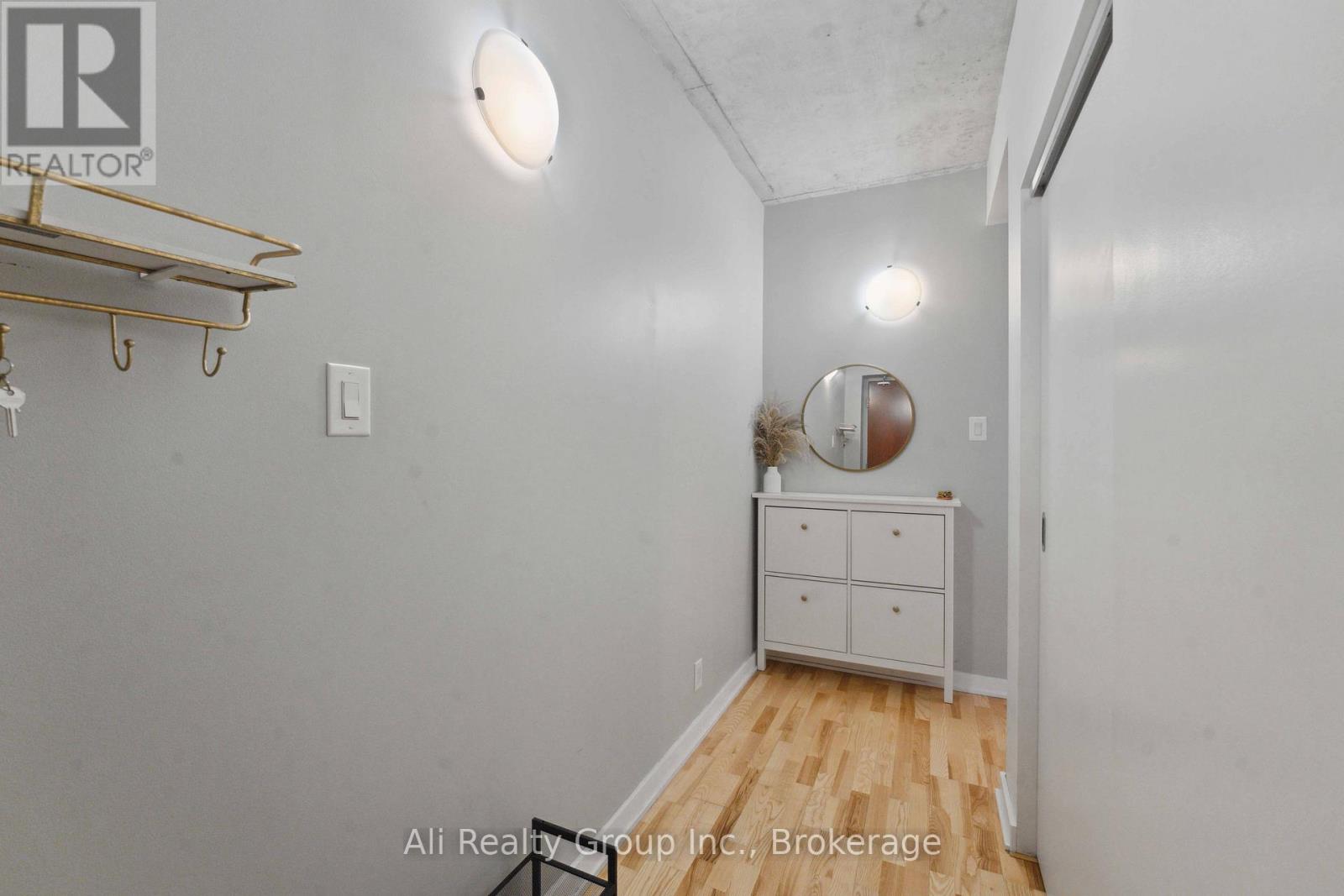 A white bedroom with a dresser and a mirror.