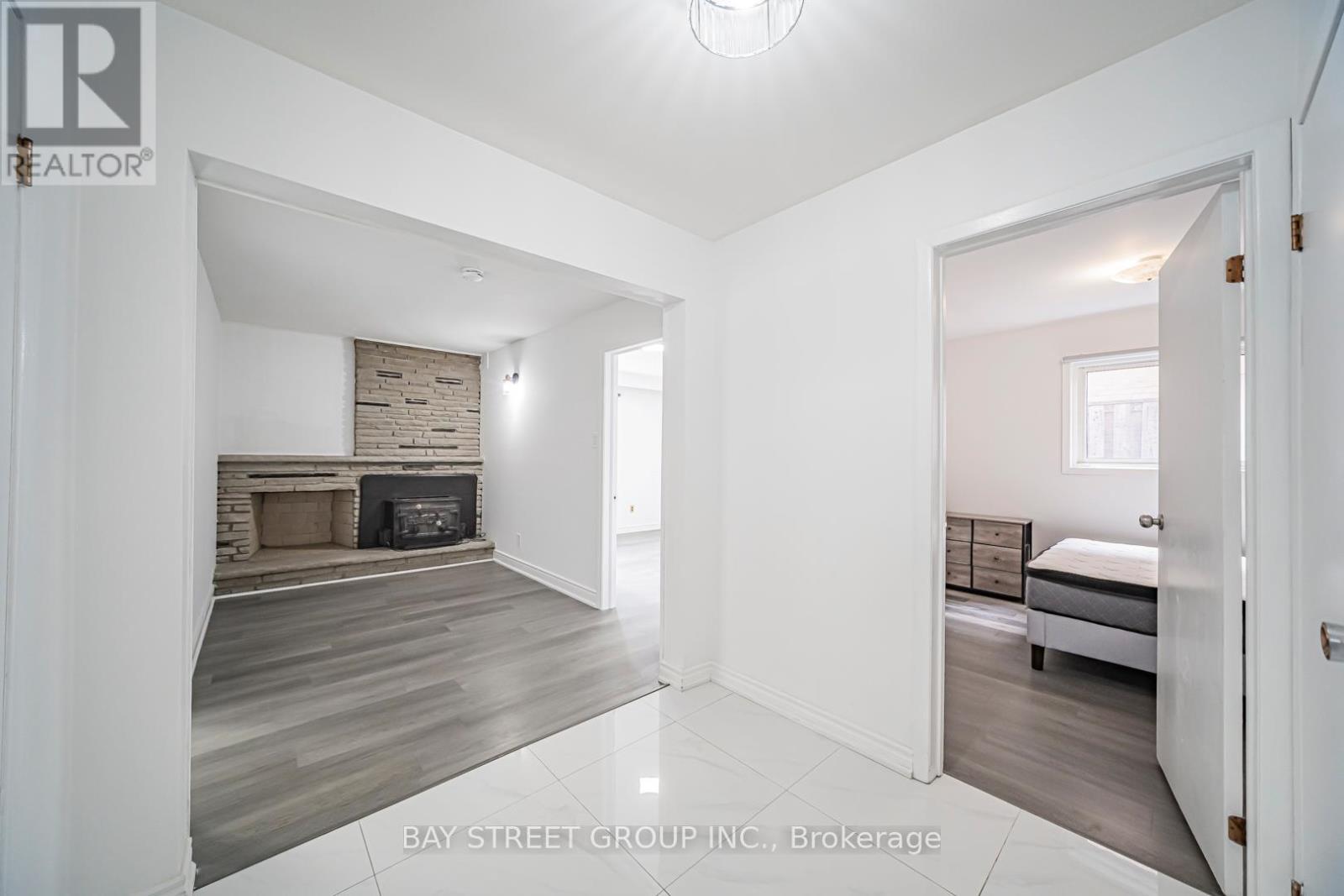 A spacious room with a fireplace and a bed in the corner.