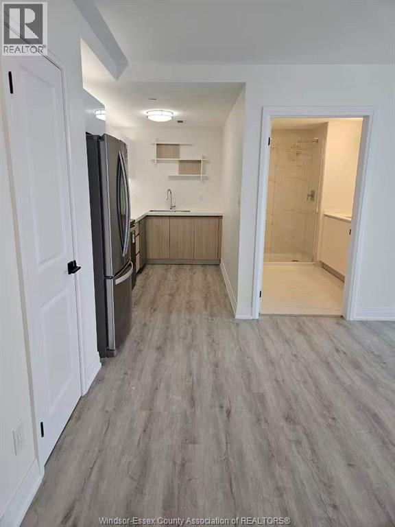 A kitchen with white cabinets and a refrigerator.